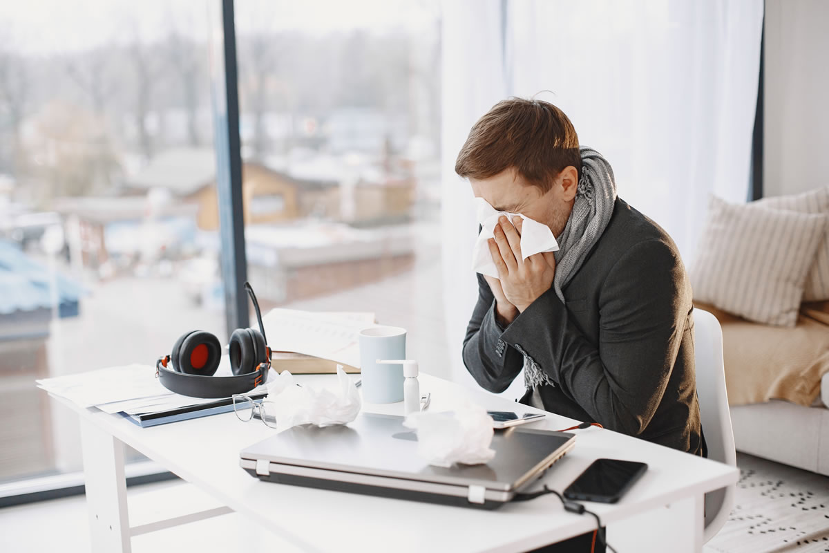 Man in office suffering from poor indoor air quality Man in office suffering from poor indoor air quality