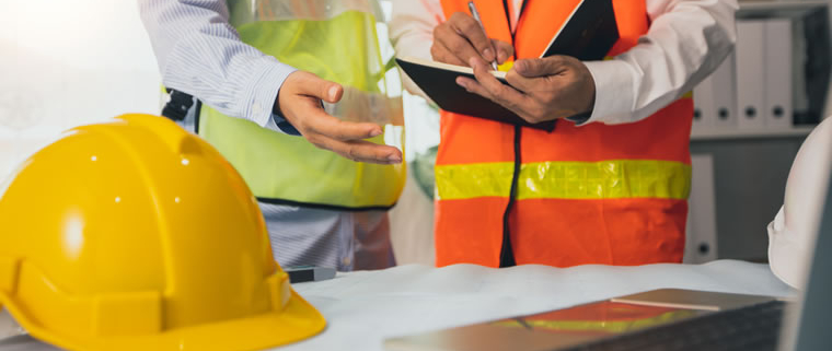 Two health and safety professionals review measures to control Legionnaires' disease in the workplace