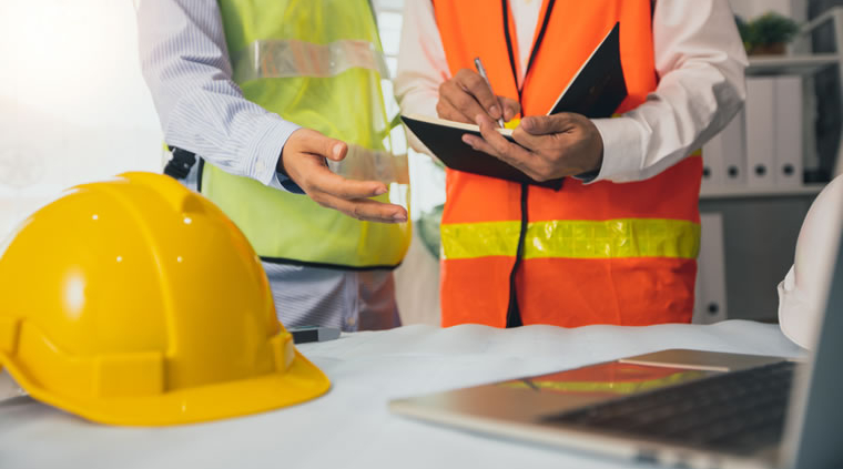 Two health and safety professionals review measures to control Legionnaires' disease in the workplace