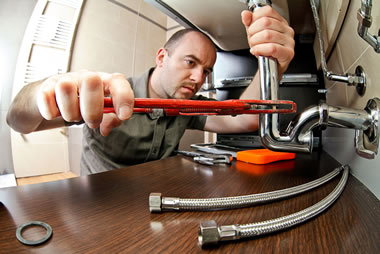 Plumber installing flexible hoses under sink