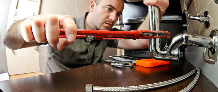 Plumber installing flexible hoses under sink